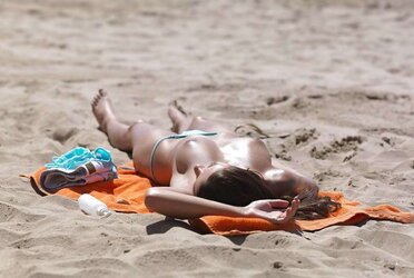 Luxurious youthful woman bare on the beach